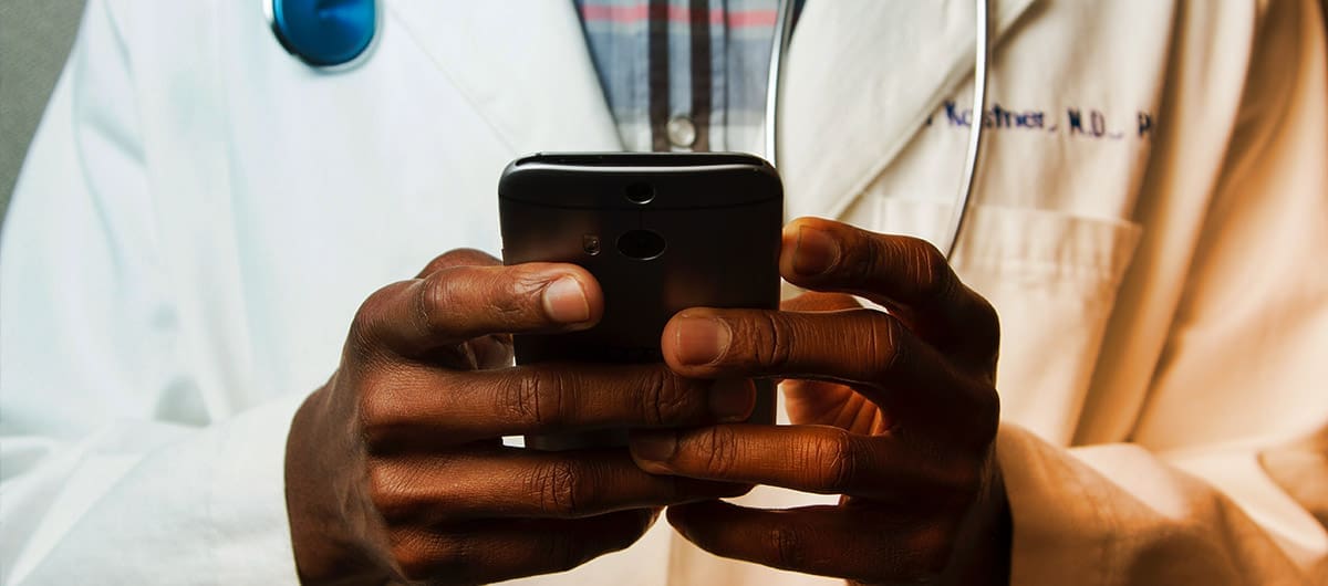 Up close view of a doctor's chest holding his cellphone