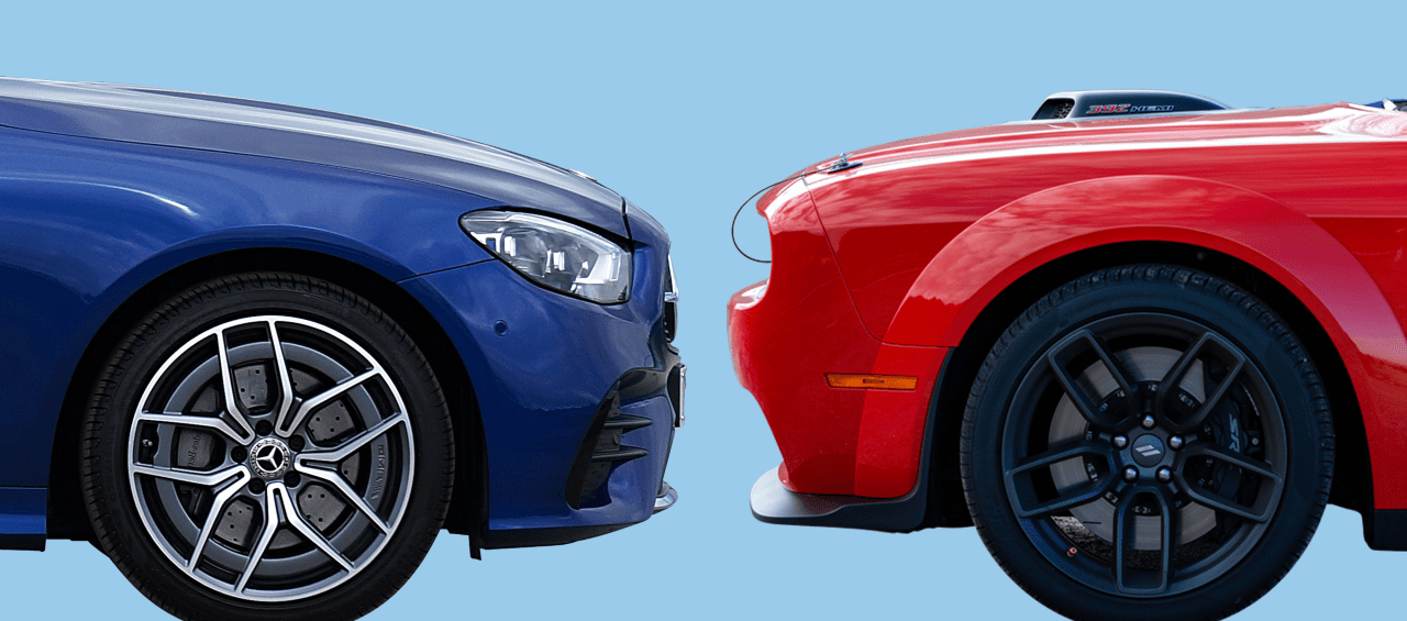 Side view of two cars facing each other, front bumper to bumper. Car on the left is blue and car on the right is red.